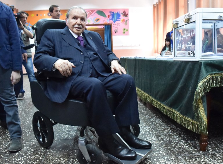 (FILES) In this file photo taken on May 04, 2017, Algerian President Abdelaziz Bouteflika is seen on a wheelchair as he casts his vote at a polling station in Algiers during parliamentary elections. - The confirmation on February 10, 2019 that Algeria's ailing President Bouteflika would contest a fifth term sparked a series of protests in the North African country. (Photo by RYAD KRAMDI / AFP)